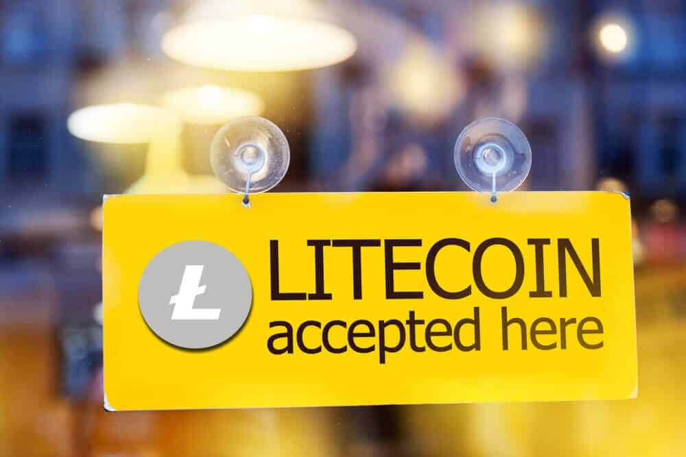 a sign stuck on a window that says Litecoin accepted here