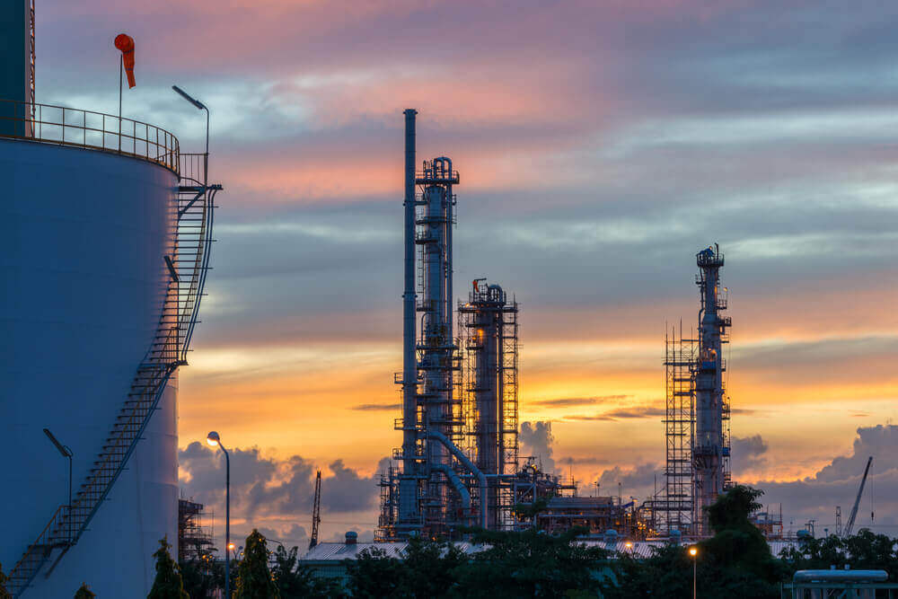 an oil refinary in Saudi Arabia with a sunset background