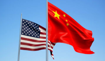 The united states flag beside the china flag as the sky is the background