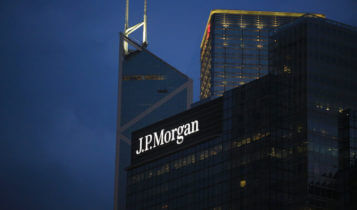 JPMorgan logo on a bulding with 2 other buildings on the background and a dark sky