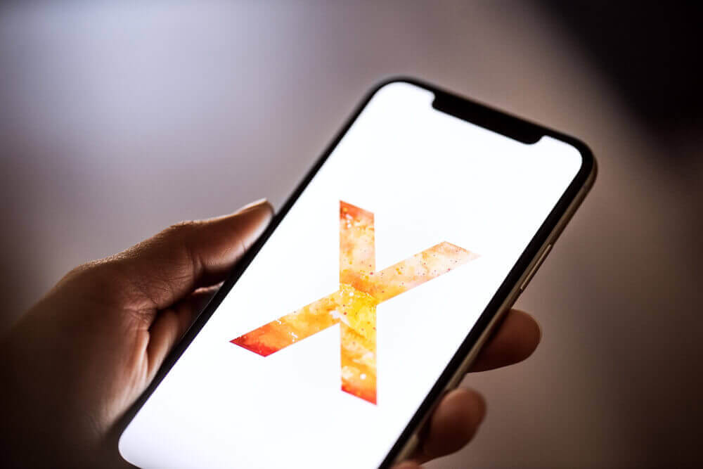 Lit up iPhone X screen being held by a person