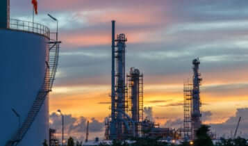 An oil refinary with blue and orange sky as a background