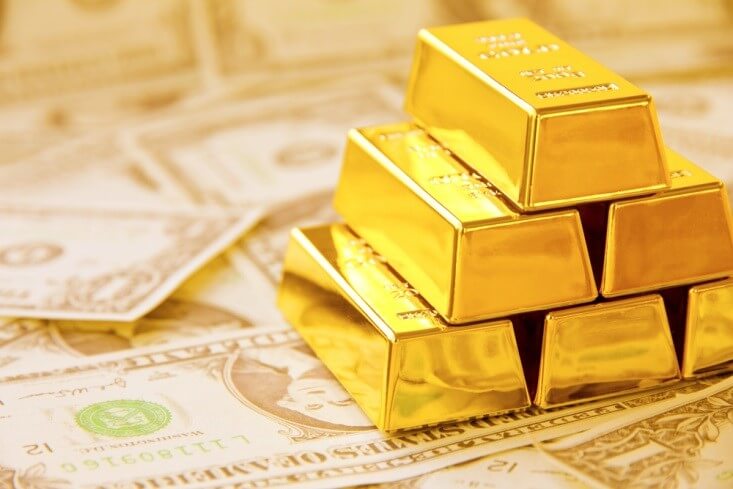 Finance Brokerage-Futures Trading: Gold bars stacked on top of each other on dollar bills 