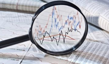 Finance Brokerage-Share Market: magnifying glass viewing charts and graphs
