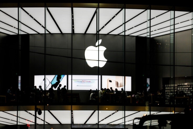 Apple logo on a large screen inside a facility -Finance Brokerage 