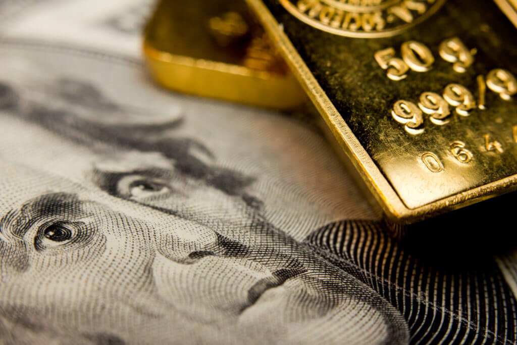 gold bullion on a dollar bill