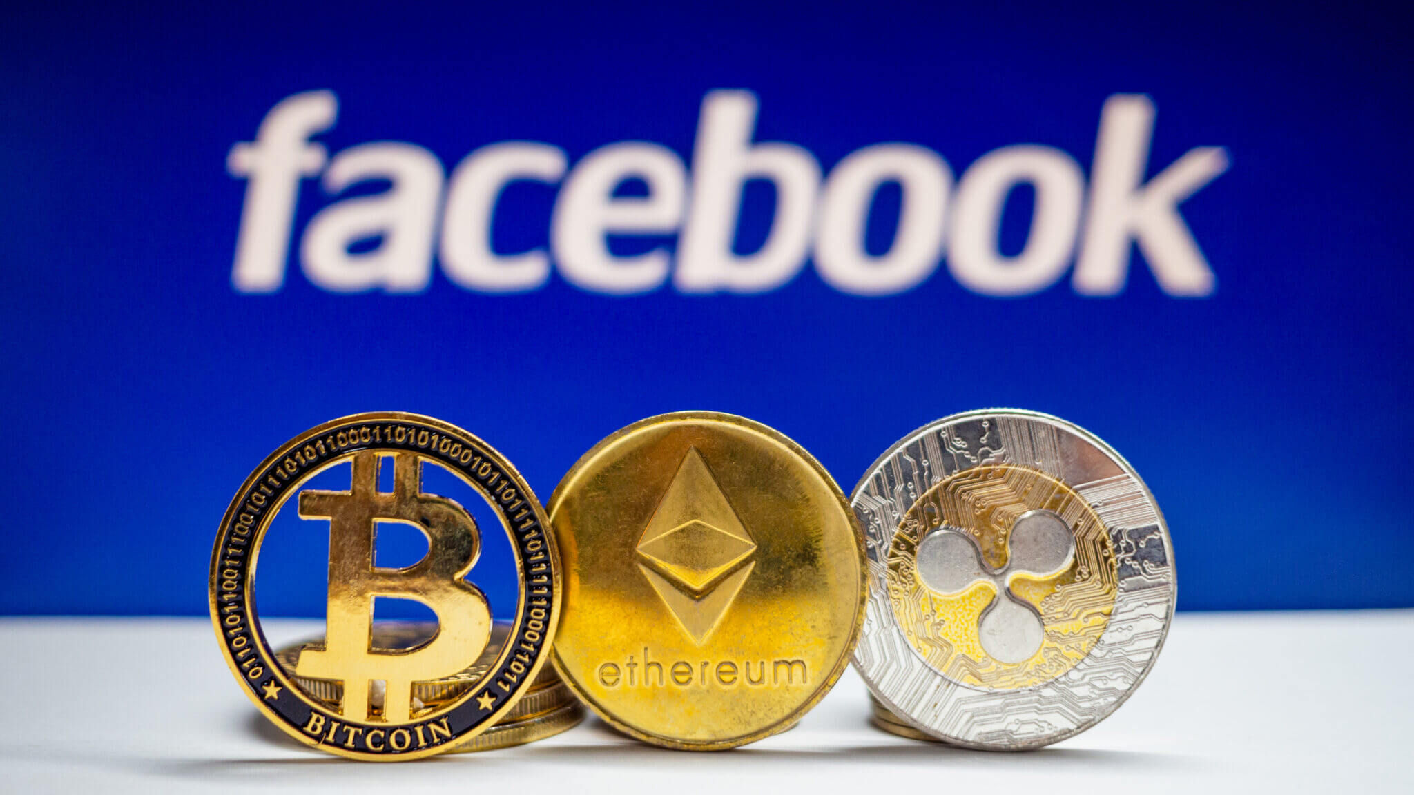 crypto tokens in front of the facebook logo