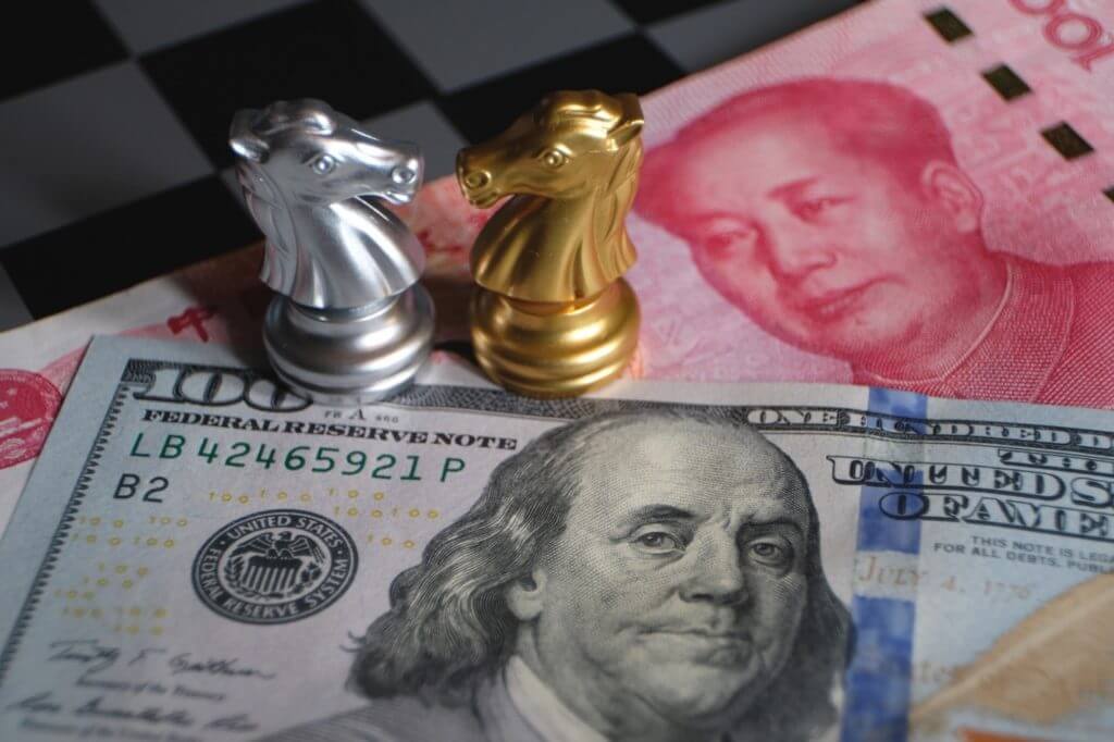 Two chess pieces over a dollar and yuan bill