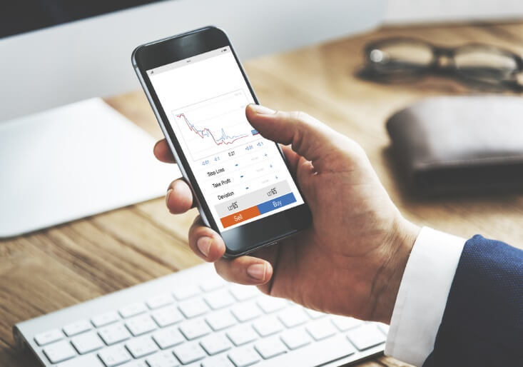 hand holding phone looking at graphs – Finance brokerage