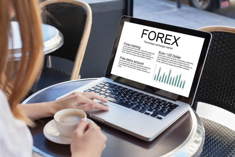 A person studying forex with a table, coffee and laptop – Finance brokerage