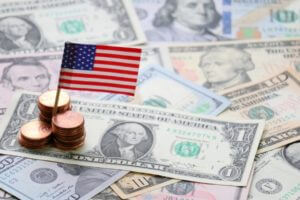 US miniature flag on top of dollar bills – financebrokerage