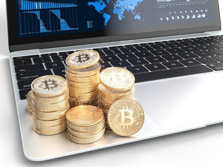 bitcoins on top of laptop
