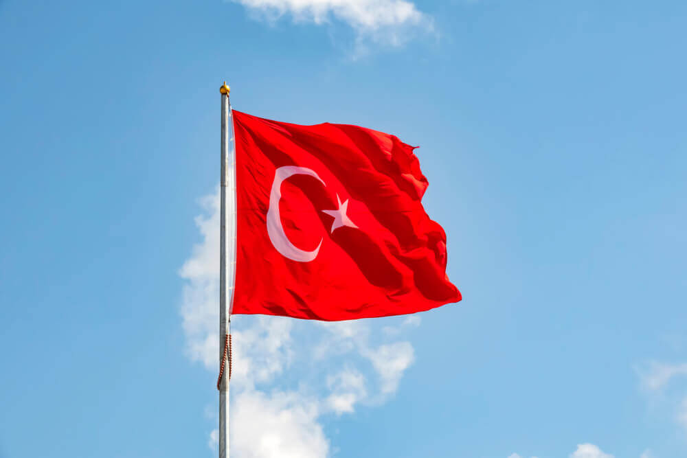 Turkish: close up turkish flag at flagpole and blue sky with clouds