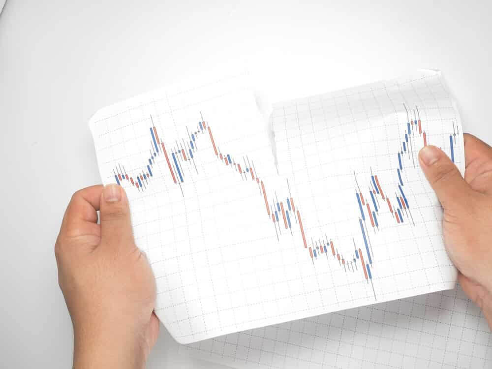 Swing trading – A man holding a paper stock chart in his hands.