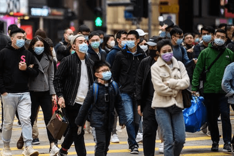 Orientais atravessando a rua com máscaras