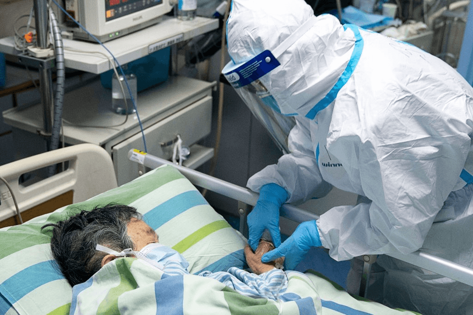 A Doctor wearing a white protective gear attending to a coronavirus patient - Finance Brokerage