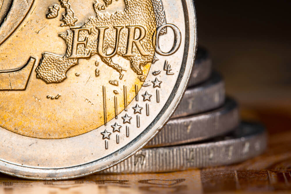 Two euro coins over euro banknotesCoins on a blurred background