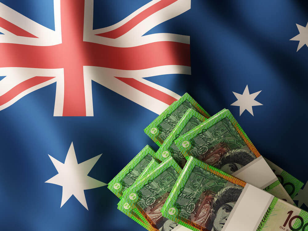 Australian dollar banknote bundles on textile textured Australia flag.