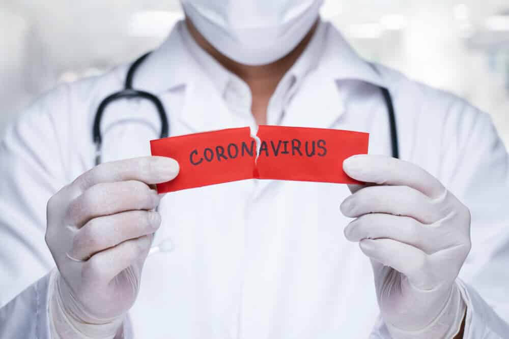 Doctor with a stethoscope Tear the red paper with the word coronavirus.
