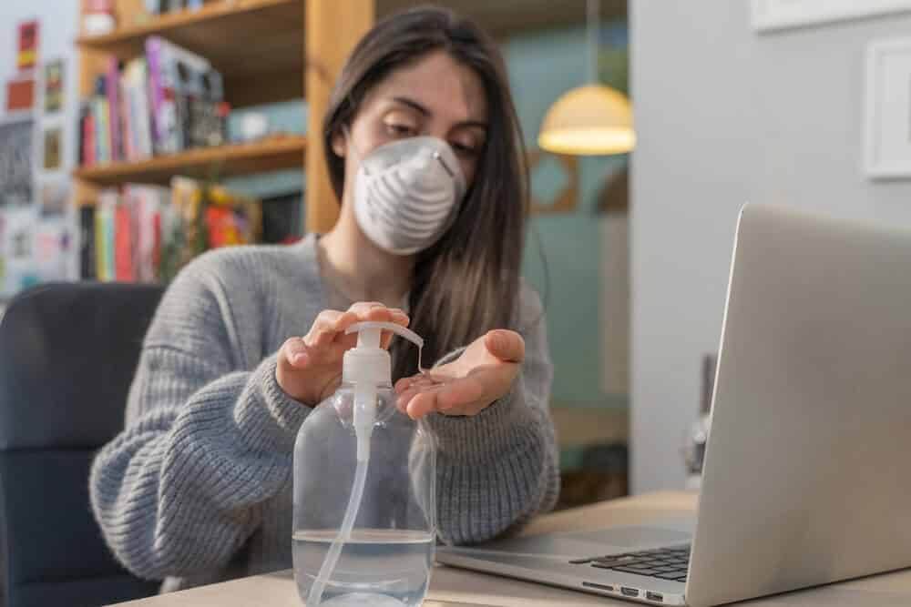 Coronavirus. Business woman working from home wearing a protective mask.