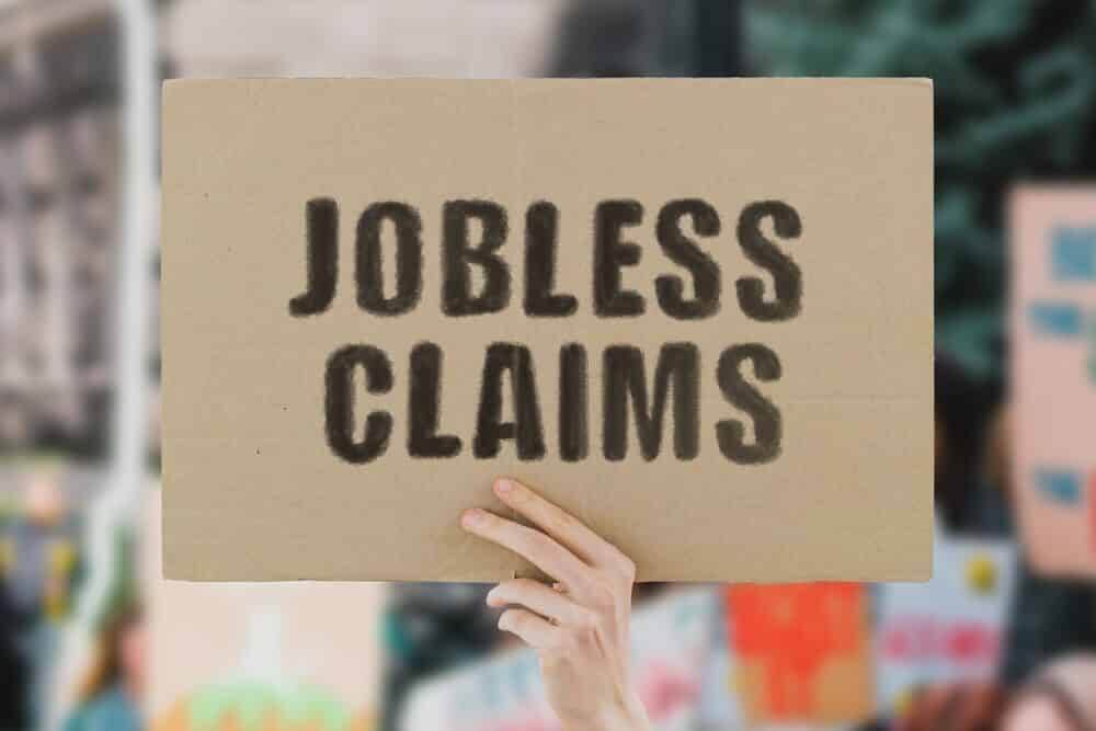 The phrase " Jobless claims " on a banner in hand.