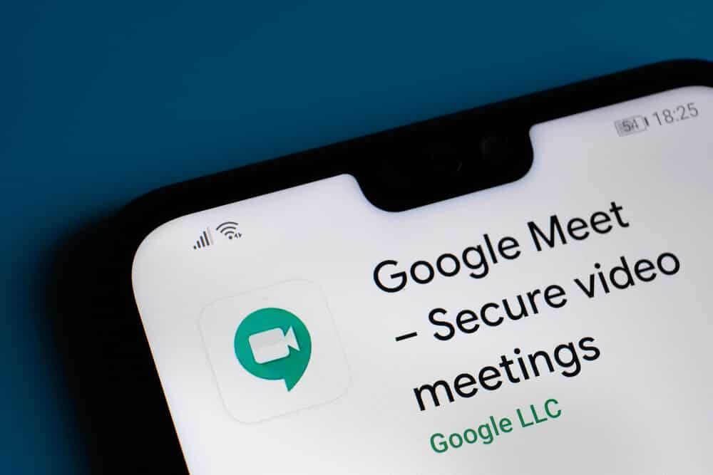 Google Meet app seen on the corner smartphone.