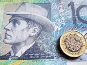 approach to australian banknote of ten dollars and coin of one sterling pound, background and texture